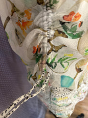 Close-up of Marccain silk blouse showcasing intricate thread detailing and floral patterns.