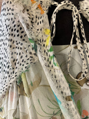 Close-up of a sheer Marccain silk blouse showcasing delicate thread detailing and floral patterns.