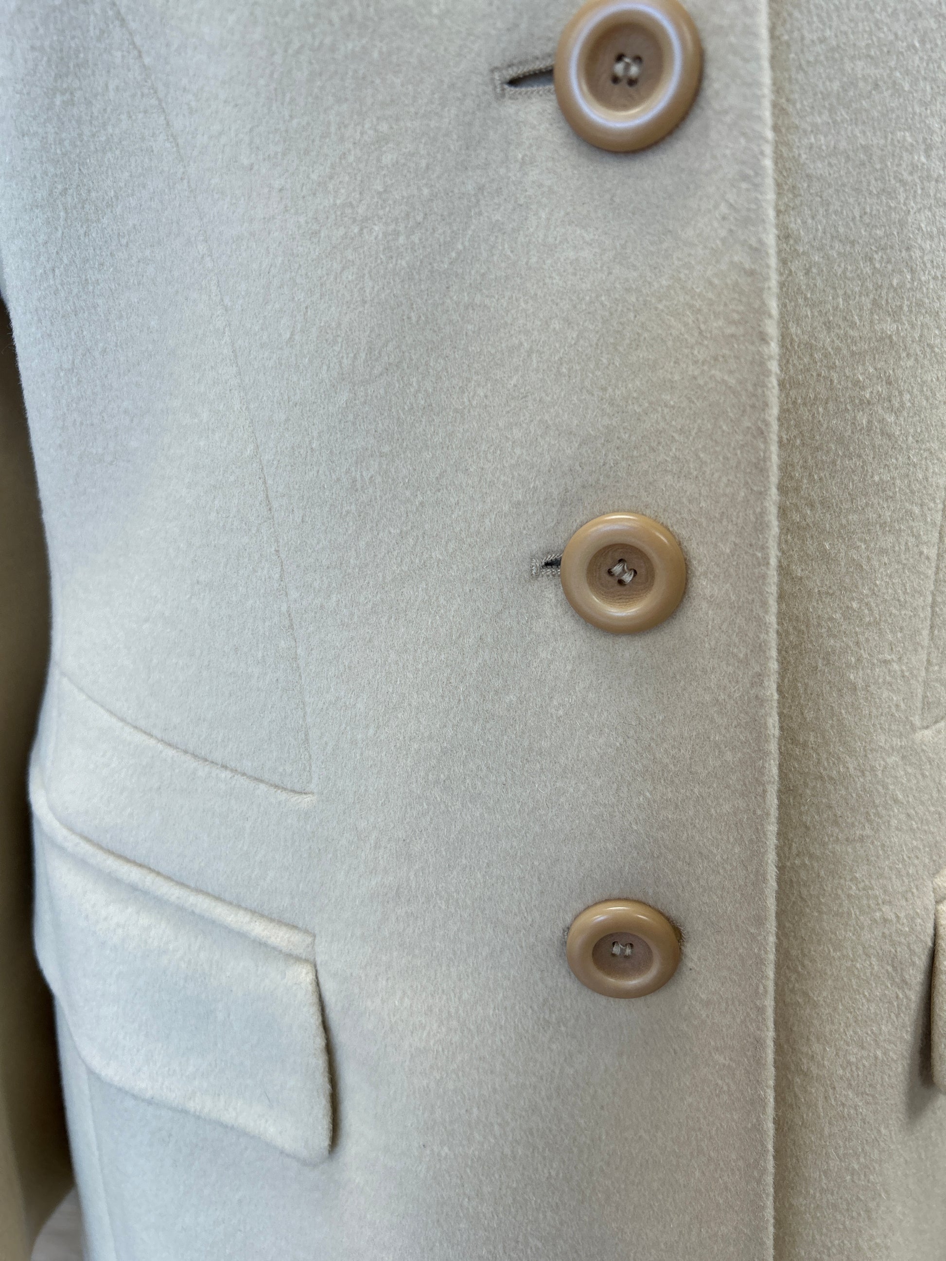 Close-up of the Laurel Creamy Wool Coat showing soft fabric, buttons, and pockets for an elegant outerwear look.