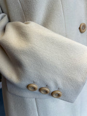 Close-up of Laurel Creamy Wool Coat sleeve with buttons, showcasing elegant design and luxurious fabric.