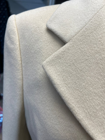 Close-up of Laurel Creamy Wool Coat, showcasing its soft wool texture and elegant lapel design.