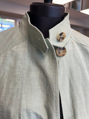 Close-up of Nic Janik Green Linen Coat featuring two style collars and buttons, showcasing its light green color and linen texture.