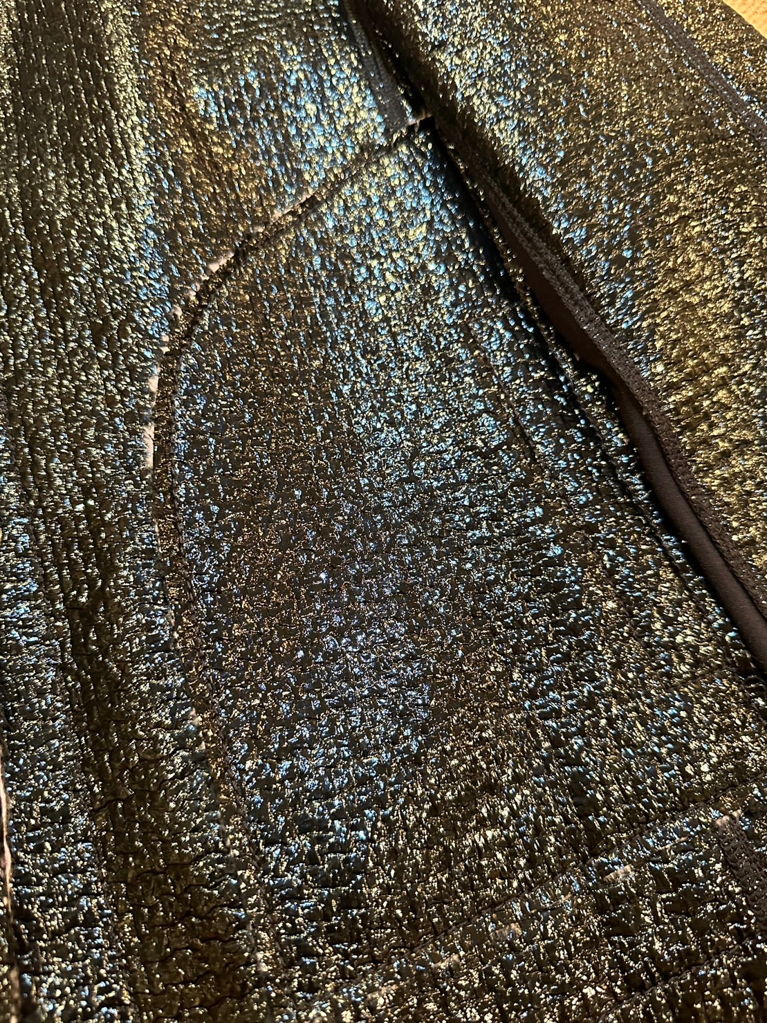 Close-up of the shimmering black leather texture of Marccain Reversible Jacket, showcasing its elegant design.