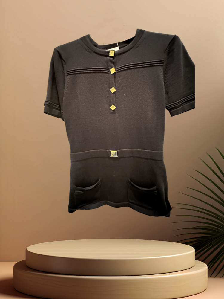 Elegant black blouse with front buttons and pockets, showcased on a pedestal against a minimalist backdrop.