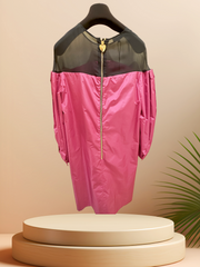 Vibrant pink dress with black tulle shoulders, featuring a zipper detail, displayed elegantly on a hanger.
