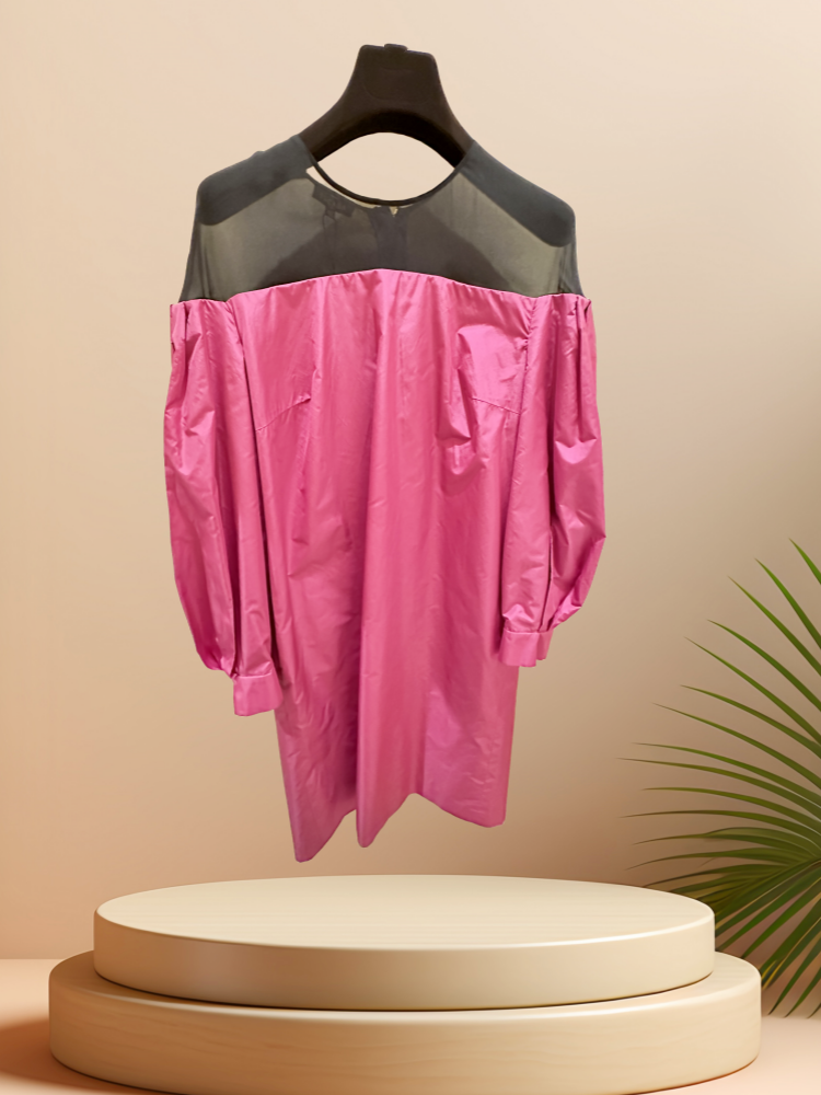 Vibrant pink off-the-shoulder dress with black tulle neckline displayed on a pedestal, perfect for stylish occasions.