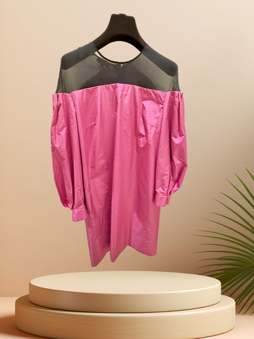 Vibrant pink off-the-shoulder dress with black tulle neckline displayed on a pedestal, perfect for stylish occasions.