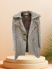 Marccain Black/White Houndstooth Coat displayed on a podium, showcasing its sleek design and stylish pattern.