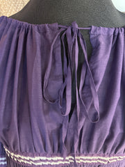 Close-up of Jean's Paul Gaultier purple blouse with puff sleeves and tie detail at the back.
