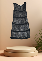 Marccain stylish black knitted dress displayed on a pedestal, showcasing its unique layered design and modern aesthetic.