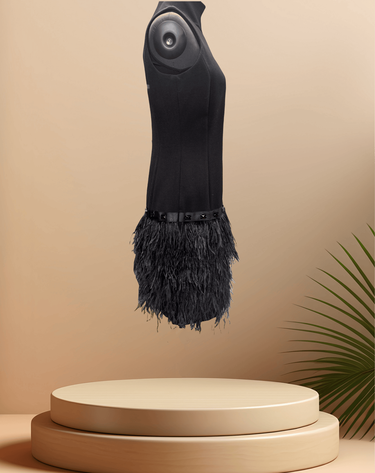 Michael Kors Black Feather Dress with a stylish feather skirt displayed on a pedestal against a soft background.