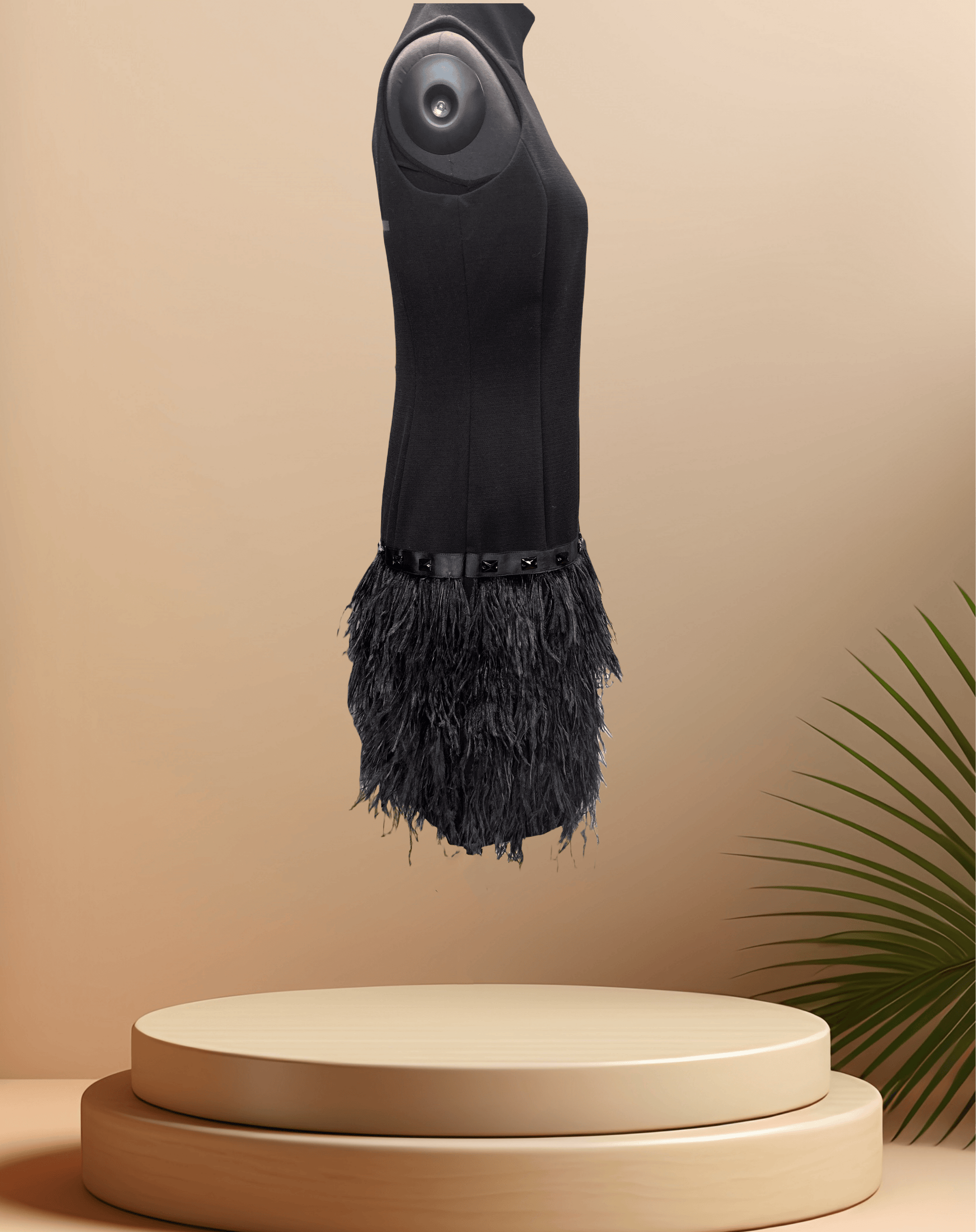Michael Kors Black Feather Dress with a stylish feather skirt displayed on a pedestal against a soft background.