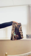 Marccain flower and butterfly printed skirt held up for display, showcasing its slim fit and whimsical design.