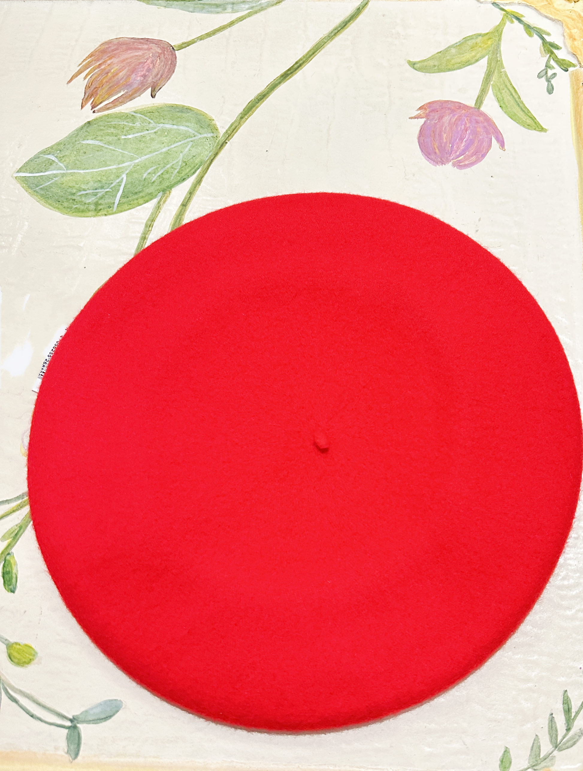Red wool beret on a floral background, showcasing premium quality and stylish design.