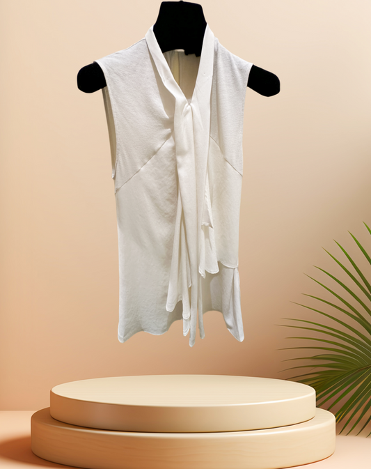 Seventy Blouse in creamy color, made from 70% viscose and 30% lana wool, displayed on a pedestal with palm leaves.